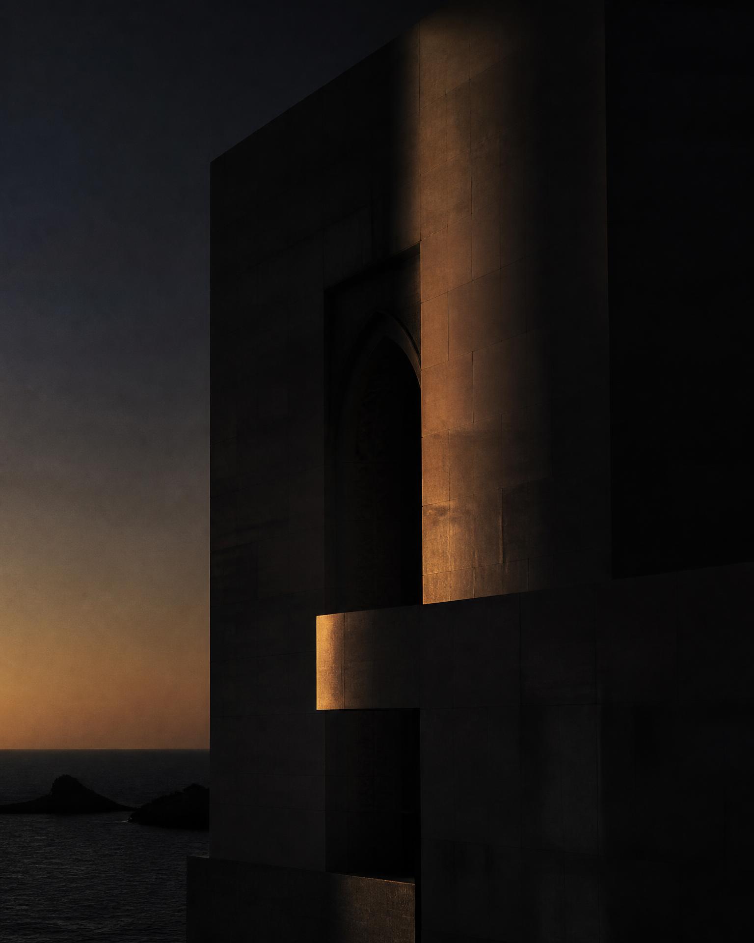 Modern Omani stone architecture at dusk with a bronze shaft of light and the sea beyond