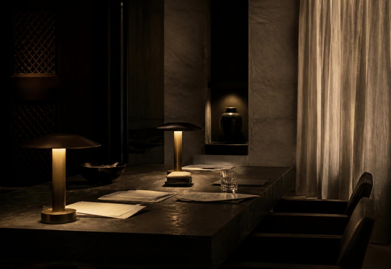 A private advisory table in Muscat, lit by two low bronze lamps